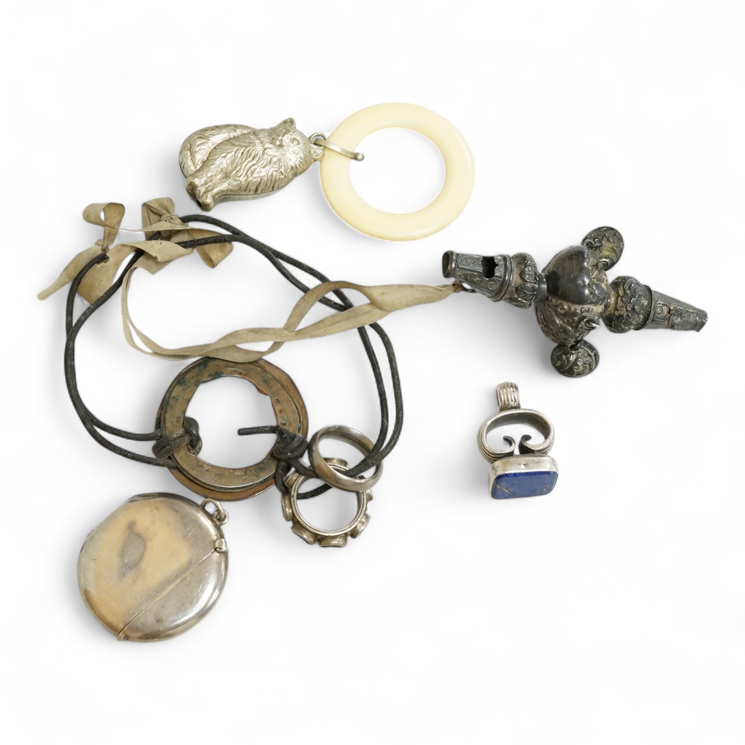 A George V silver circular vesta case, S. Blanckensee & Son Ltd, Birmingham, 43mm, together with a damaged silver child's rattle by George Unite, a cat child's rattle, white metal and lapis lazuli set fob, etc.